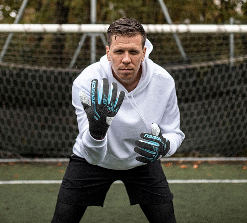 Torwart mit Reusch Torwarthandschuhen steht konzentriert vor dem Tor auf dem Spielfeld.