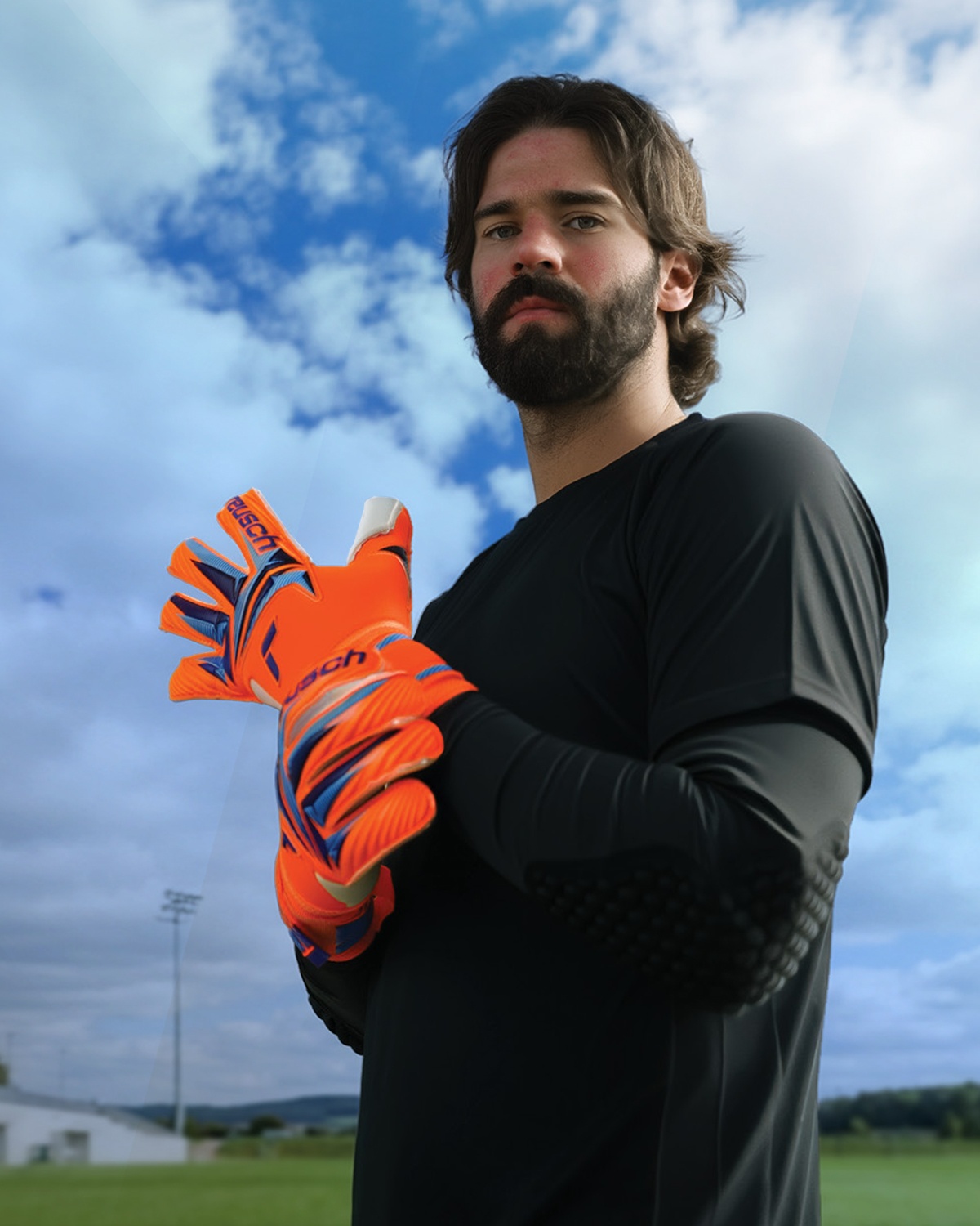 Torwart mit blauen Reusch-Torwarthandschuhen vor dunklem Hintergrund, Fokus auf Grip und Design